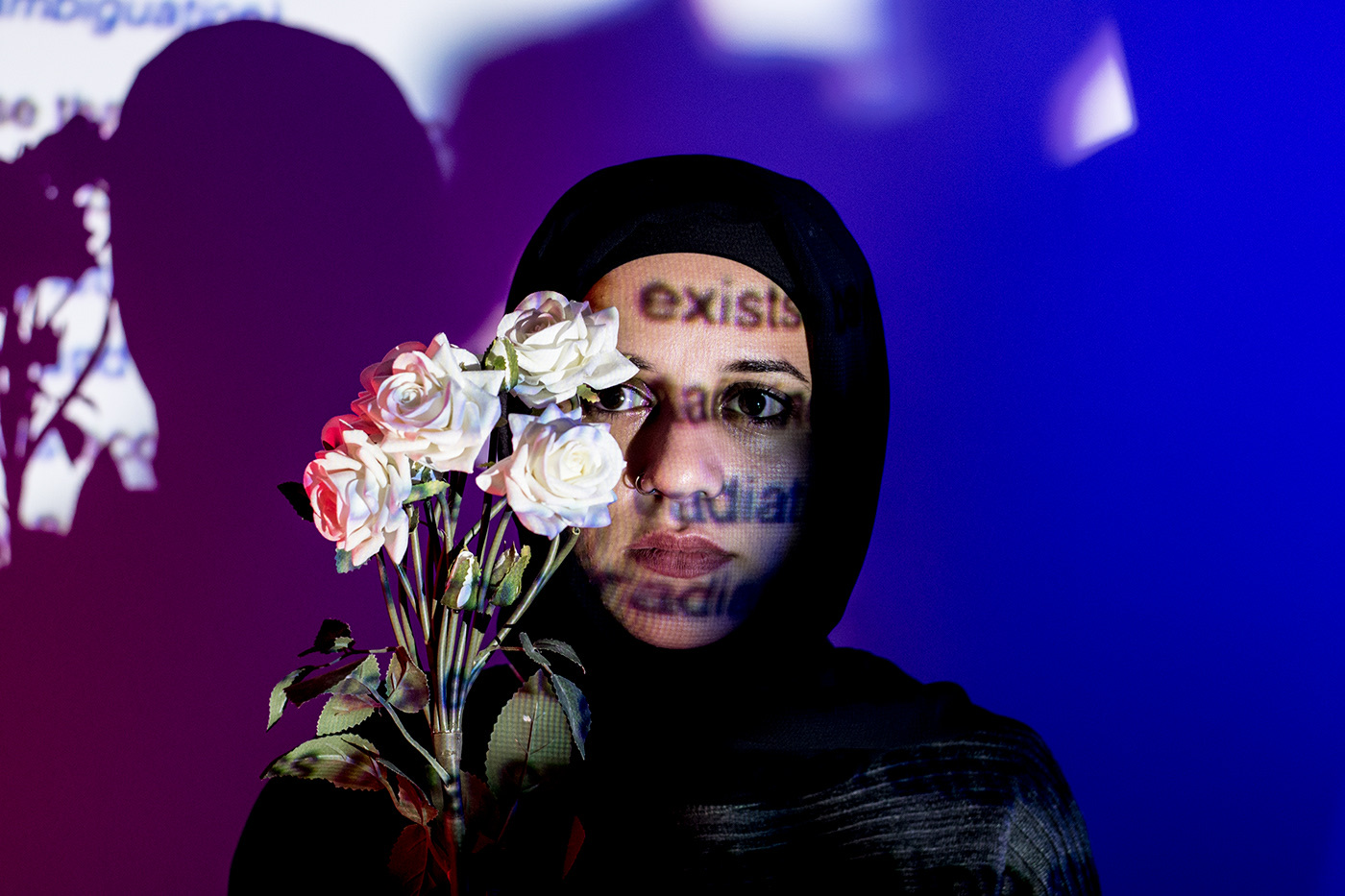 Portrait with projected type and flowers in blue light