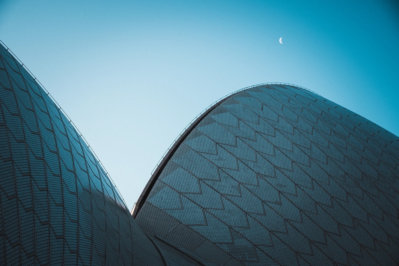 Tiled sails against a blue sky with the moon