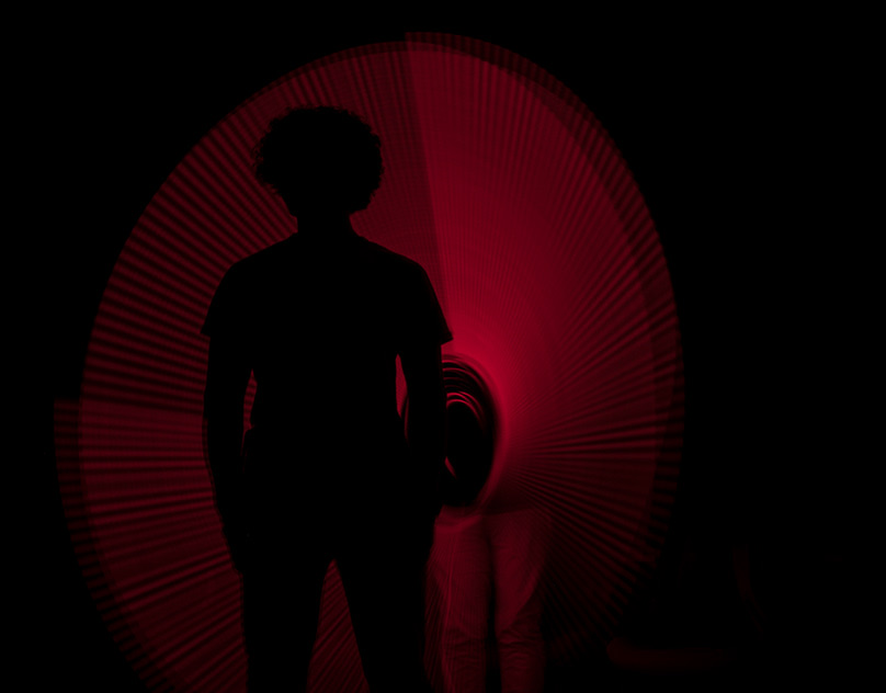 Silhouette in front of a red light-painted circle