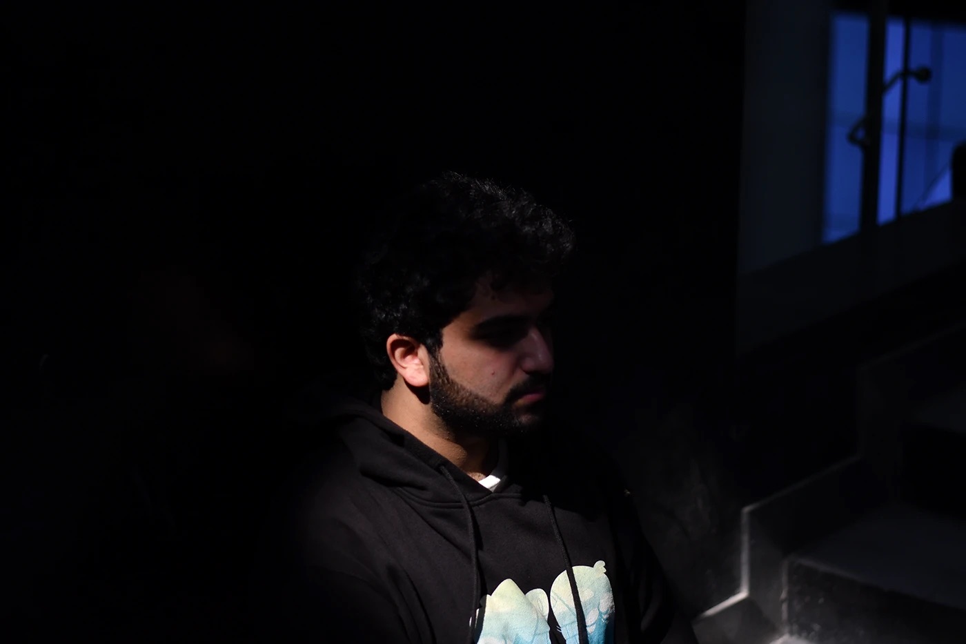Man lit from the side in darkness