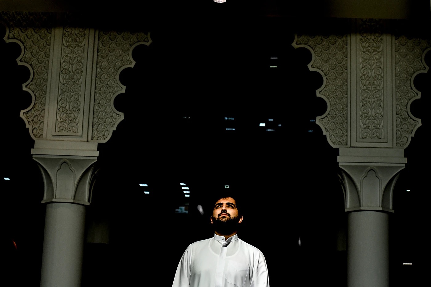 Man in white under carved arches
