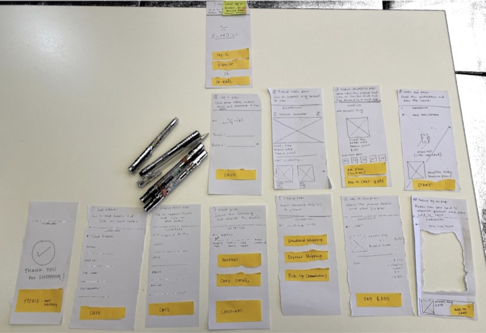 Paper prototype screens laid out on a table