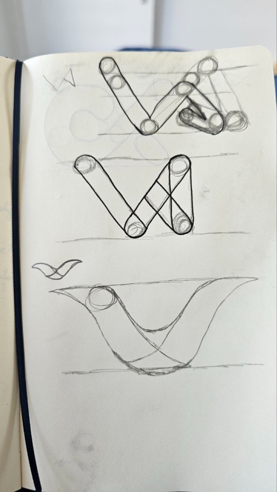 Sketchbook page of early V letterform logo sketches
